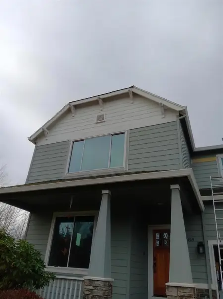 New upper-story picture window on a green craftsman two-story with a covered porch
