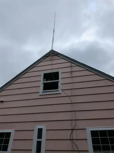 White double-hung in the gable of a pink shake house